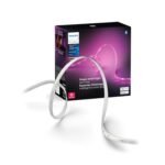 Philips Hue Lightstrip Base Kit white LED strip with purple gradient packaging shown in a modern bedroom with warm ambient ceiling lighting