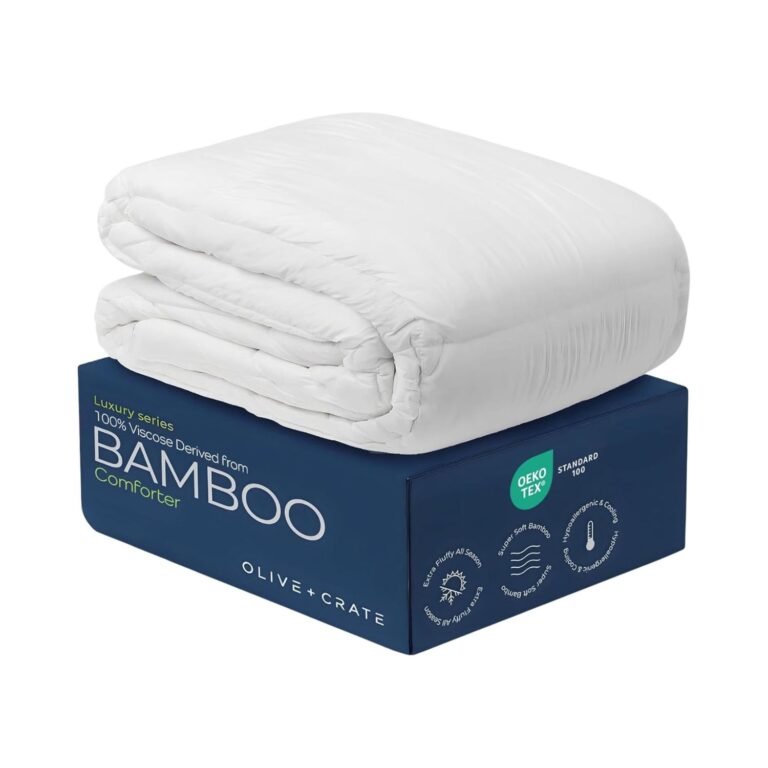 White fluffy Olive + Crate bamboo comforter folded on navy blue luxury packaging box with OEKO-TEX certification