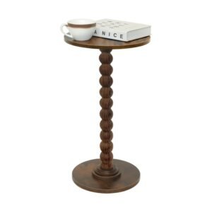 Brown wooden pedestal round side table with carved spindle base displaying white coffee cup and books
