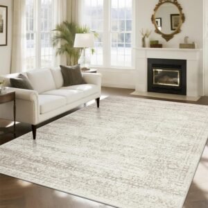Large ivory and beige vintage distressed low-pile area rug in elegant living room with white sofa and fireplace