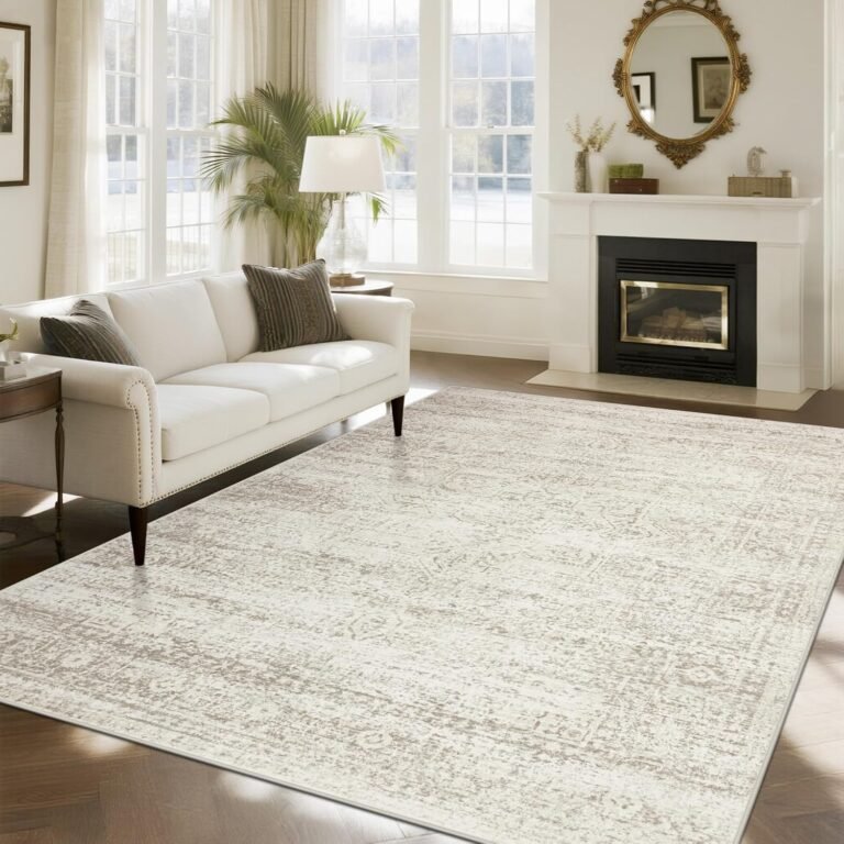 Large ivory and beige vintage distressed low-pile area rug in elegant living room with white sofa and fireplace
