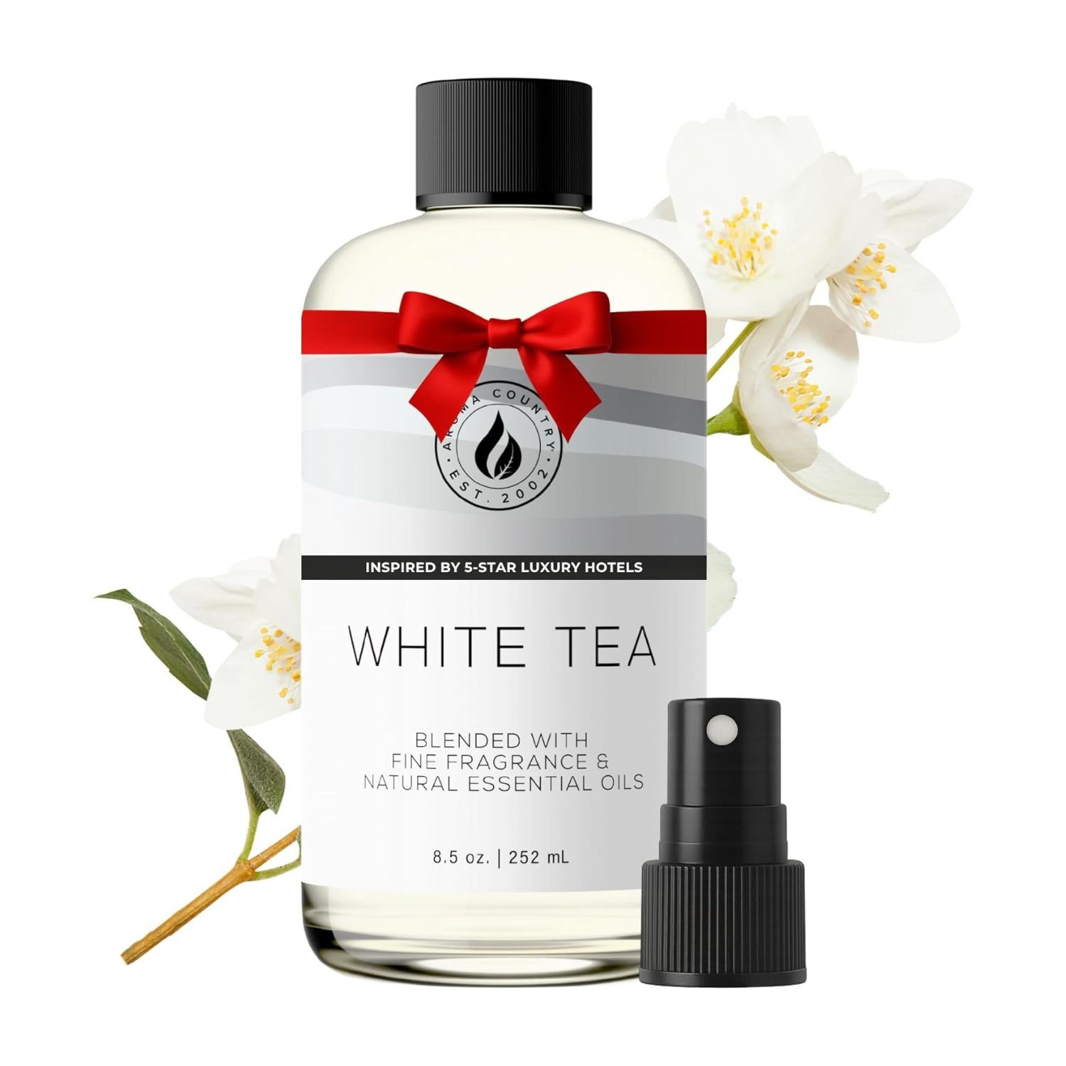 Ultimate Aroma Country Essential Oil Review – 3-Way Long-Lasting Fragrance for Home & Office 1 Frosted glass bottle of Aroma Country essential oil (white tea) with red ribbon bow, spray pump, and white jasmine flowers