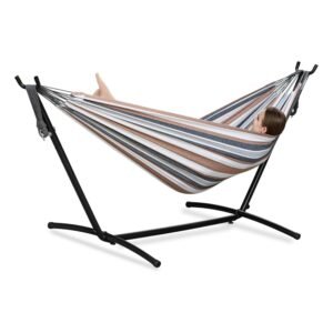 PNAEUT double hammock in brown, grey, and blue stripes on black metal stand with person relaxing comfortably