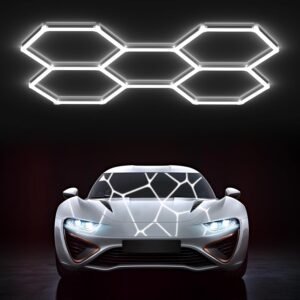 Six white Hexagon LED Light Gen 2 panels linked in honeycomb pattern glowing bright white above silver sports car in dark garage