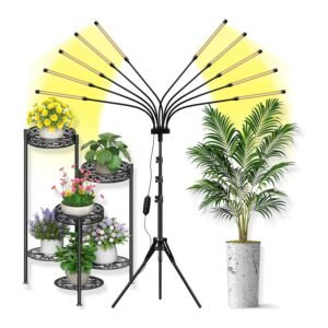 Yehsence grow light with ten LED arms on tripod stand, emitting yellow spectrum light over flowering plants and a palm tree indoors